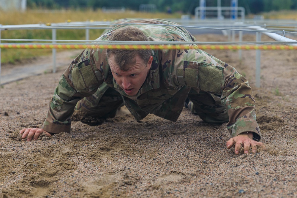 Sgt. 1st Class Shane Price crawls under an obstacle