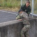Capt. Mille Hewalo helps her teammate Maj. Nicole Dallocchio up an obstacle
