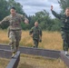 Maj. Nicole Dallocchio and Capt. Mille Hewalo balance on a beam