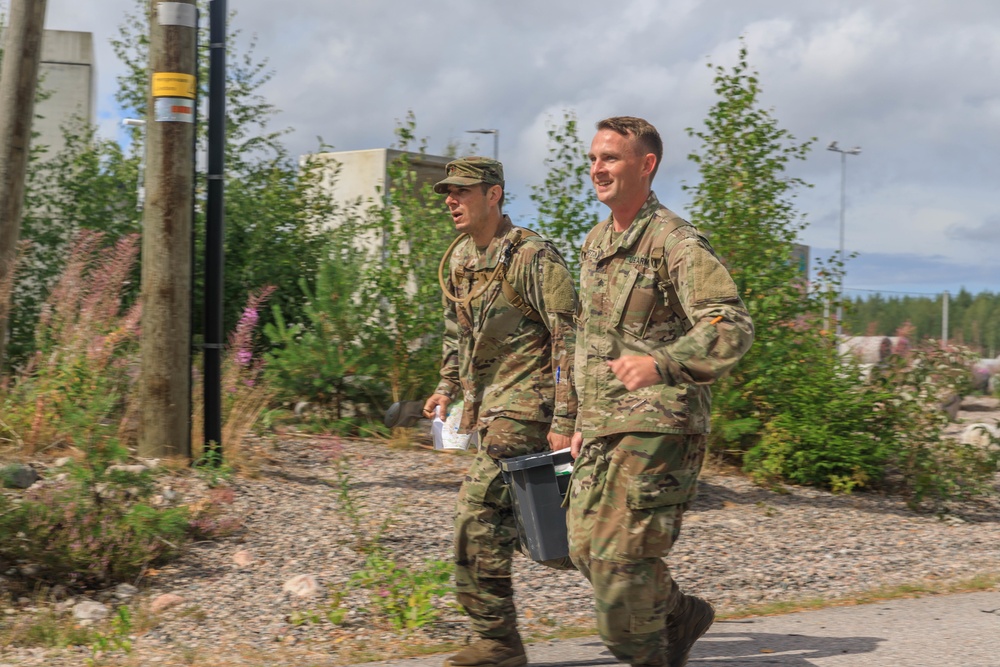 Maj. James Fink and Sgt. Michael Yarrington carry a weight to the finish