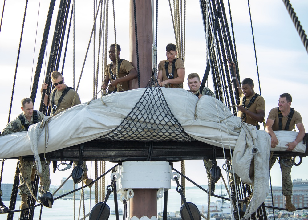 Sailors furl the mizzen topsail aboard USS Constitution