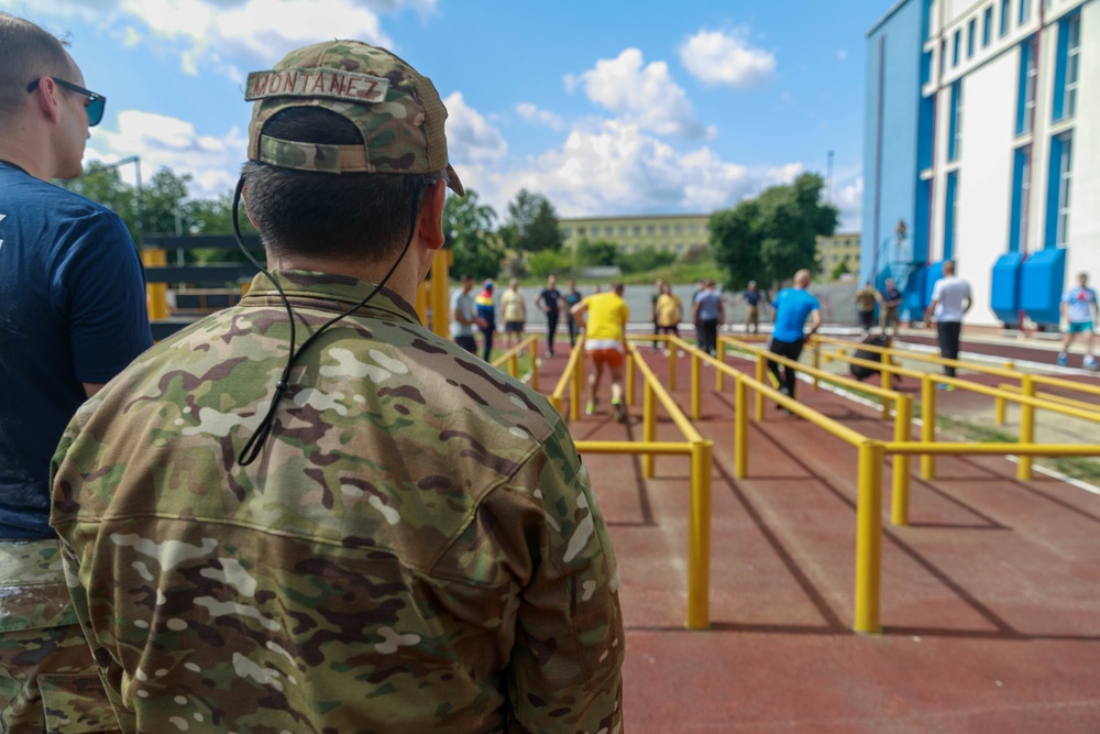 Col. Ryan “MZ” Montanez watches as Romanian Reserve service members run through an obstacle
