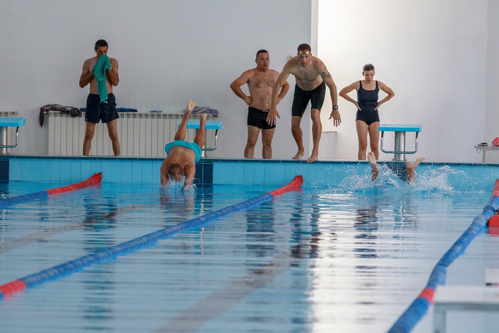 American reserve service members train Romanian Reserve service members on the water obstacle course