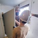 Seabees assigned to Naval Mobile Construction Battalion (NMCB) 133 attach a bathroom partition as as part of a bathroom renovation on board Marine Corps Air Station Cherry Point in support of Large-Scale Exercise 2021