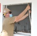 A Seabee assigned to Naval Mobile Construction Battalion (NMCB) 133 repairs a window opening as as part of a bathroom renovation on board Marine Corps Air Station Cherry Point in support of Large-Scale Exercise 2021