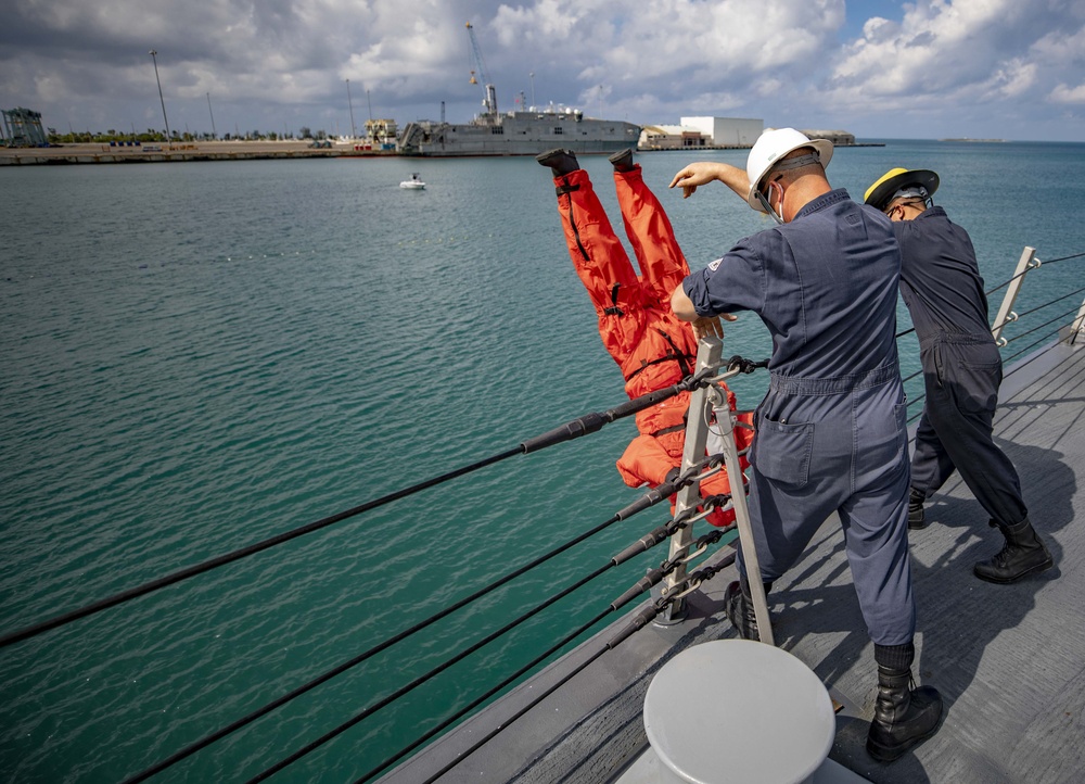 USS Billings Sailors Throw Training dummy Over the Side of the Ship During Search and Rescue Training