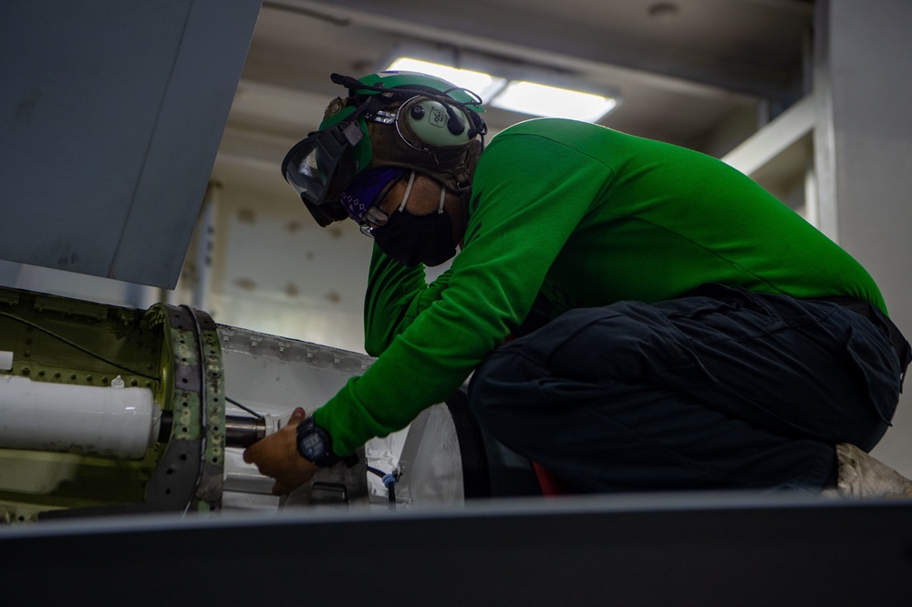 Aviation Machinist’s Mate conducts maintenance on an F/A-18E Super Hornet