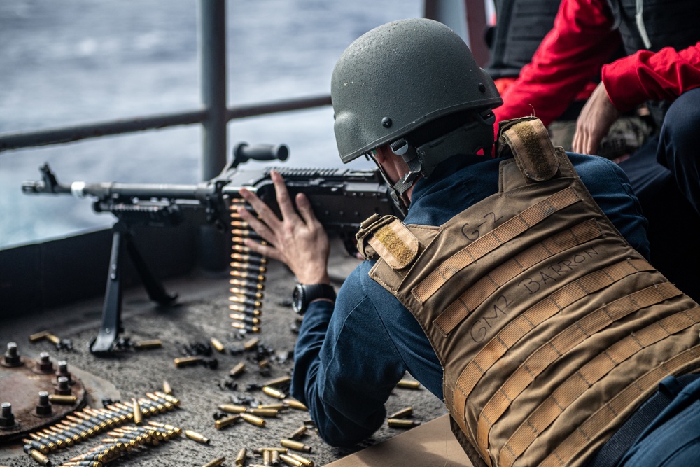 A Sailor loads an M240B light machine gun