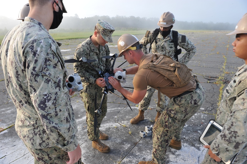 Seabees from NMCB 133 assemble a drone which will be used to survey runway damage.