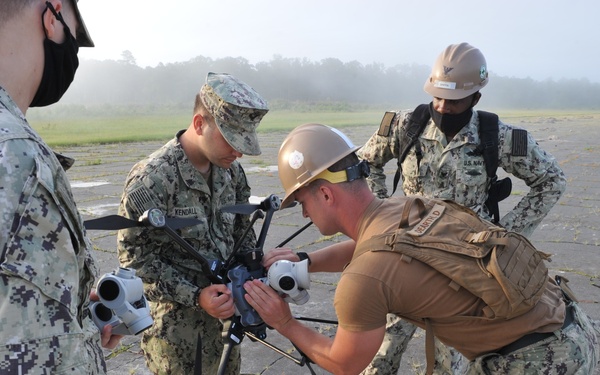 Seabees from NMCB 133 assemble a drone which will be used to survey runway damage.