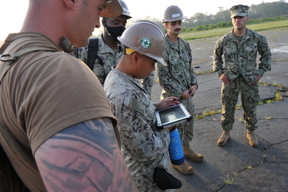 Seabees from NMCB 133 plot the area for a drone to survey in order to locate runway damage and search for possible unexploded ordnance