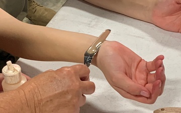 A combat moulage instructor demonstrates how to create realistic simulated combat wounds