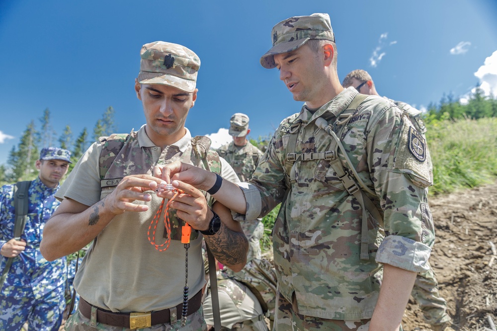 Sgt. Morgan Figgs shows a Romanian reserve Soldier orienteering techniques