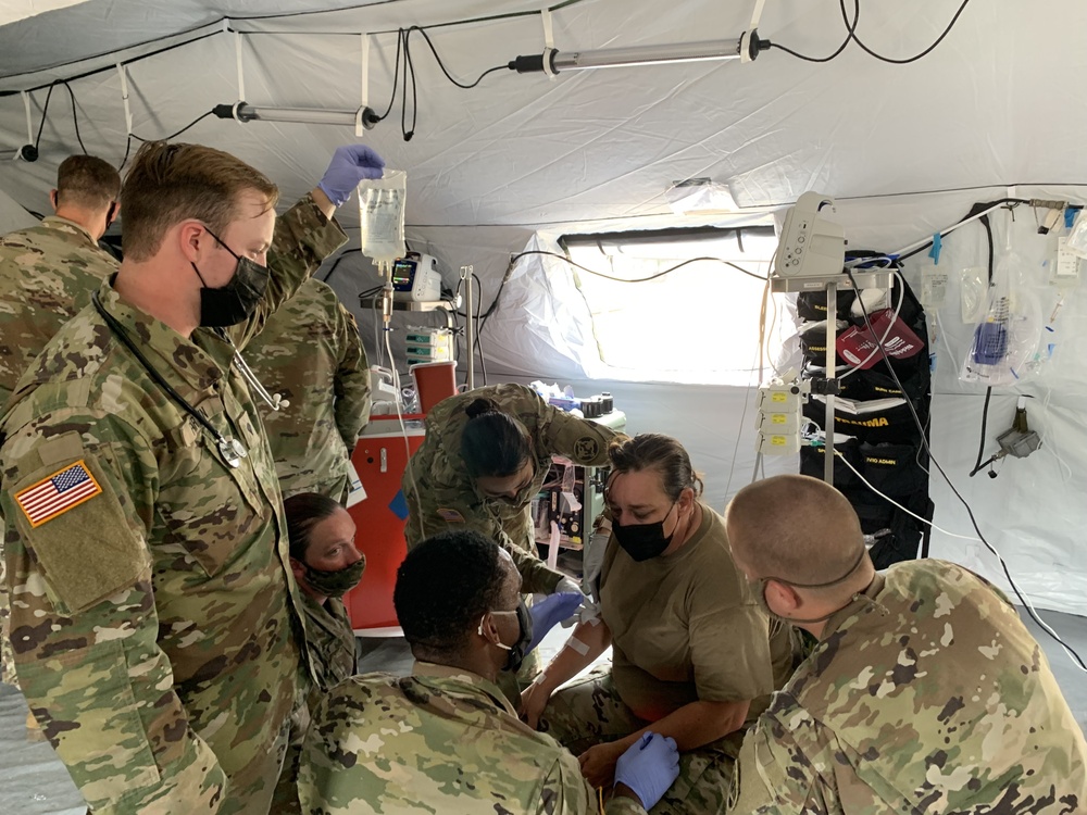 Medics work to stabilize a simulated combat casualty at Global Medic 21-02