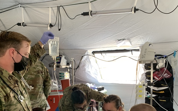 Medics work to stabilize a simulated combat casualty at Global Medic 21-02
