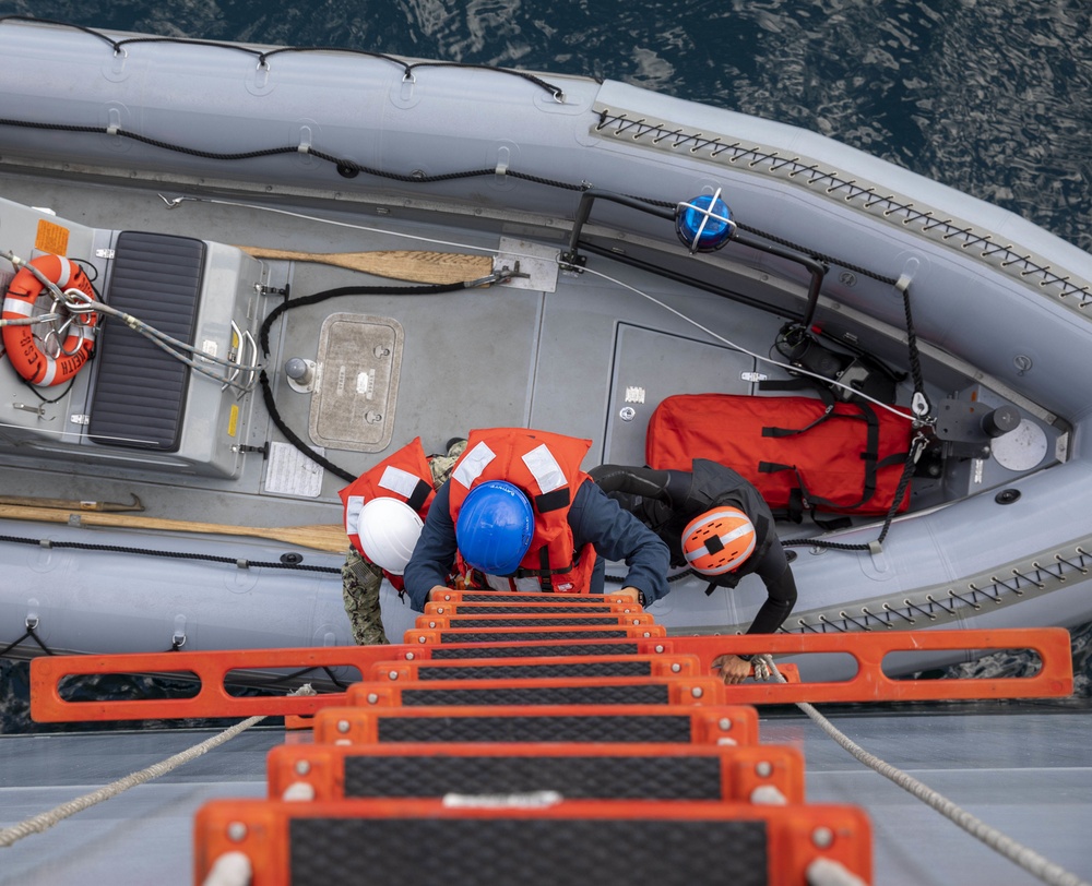 USS Miguel Keith (ESB 5) Sailors use a ladder to a RHIB