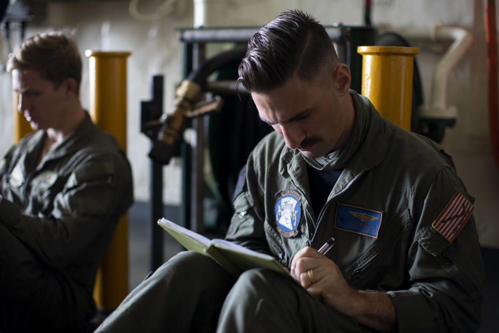 AWS3 Austin Kreilis studies for qualification board on USS Miguel Keith