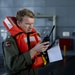 Lt. Cmdr. Doug Stahl, a pilot with Helicopter Sea Combat Squadron (HSC) 23, uses a satellite phone during a man overboard drill aboard expeditionary sea base USS Miguel Keith (ESB 5)