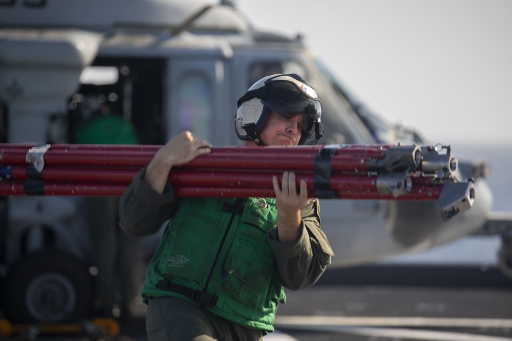 Naval Aircrewman (Helicopter) Steven Leib, assigned to Helicopter Sea Combat Squadron (HSC) 23, offloads an MH-60S Sea Hawk aboard expeditionary sea base USS Miguel Keith (ESB 5)