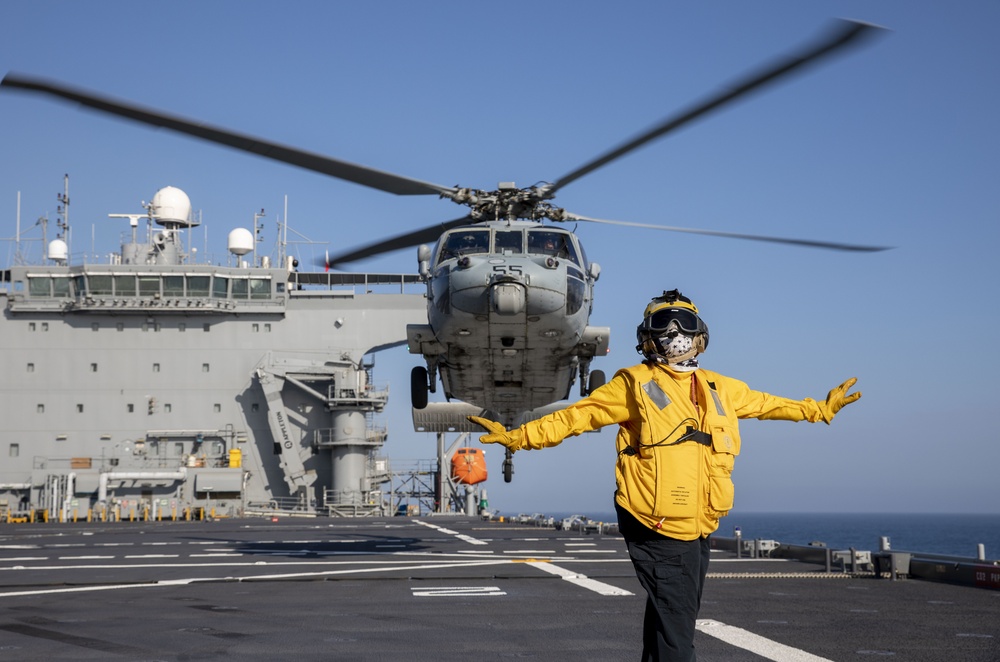 Aviation Boatswain’s Mate 3rd Class Nadezhda Zurbriggen directs an MH-60S Sea Hawk from Helicopter Sea Combat Squadron (HSC) 23 aboard expeditionary sea base USS Miguel Keith (ESB 5)