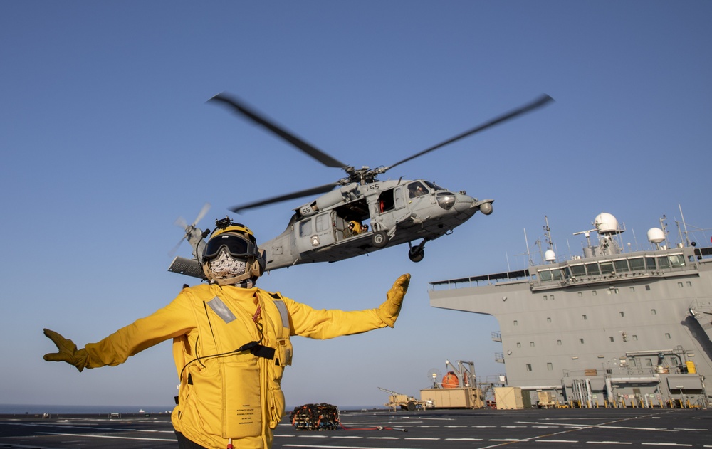 Aviation Boatswain’s Mate 3rd Class Nadezhda Zurbriggen directs an MH-60S Sea Hawk from Helicopter Sea Combat Squadron (HSC) 23 aboard expeditionary sea base USS Miguel Keith (ESB 5)