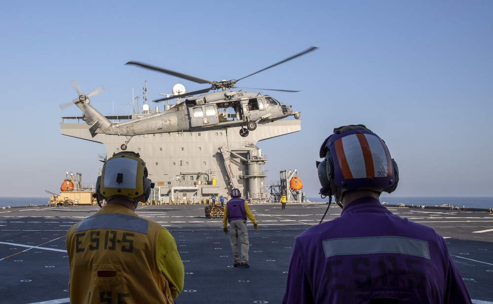 Sailors observe an MH-60S Sea Hawk from Helicopter Sea Combat Squadron (HSC) 23 during a vertical replenishment aboard expeditionary sea base USS Miguel Keith (ESB 5)