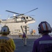 Sailors observe an MH-60S Sea Hawk from Helicopter Sea Combat Squadron (HSC) 23 during a vertical replenishment aboard expeditionary sea base USS Miguel Keith (ESB 5)