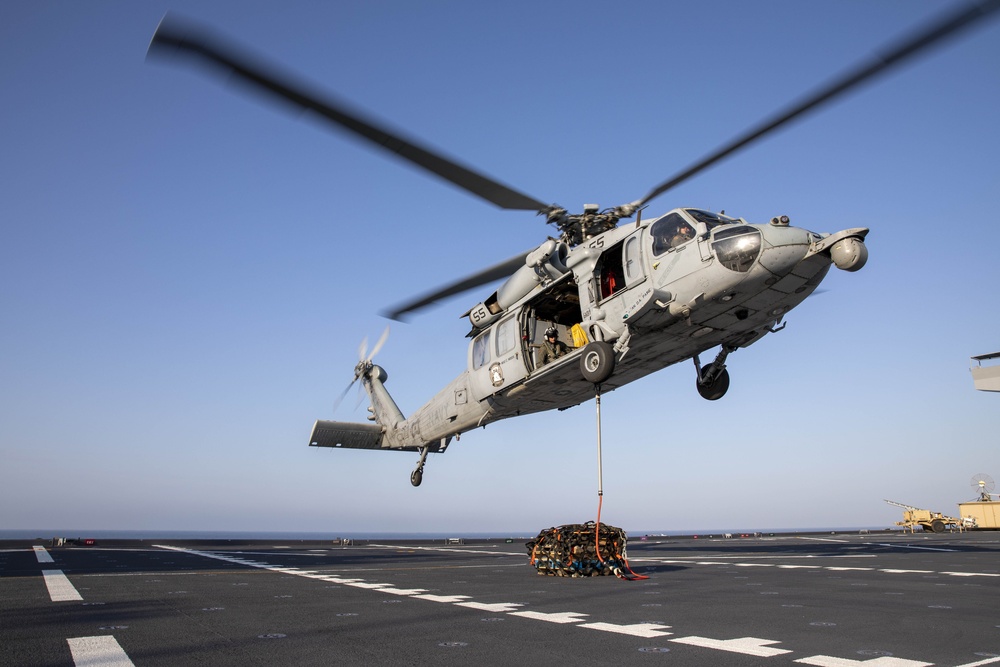 An MH-60S Sea Hawk from Helicopter Sea Combat Squadron (HSC) 23 conducts a vertical replenishment aboard expeditionary sea base USS Miguel Keith (ESB 5)