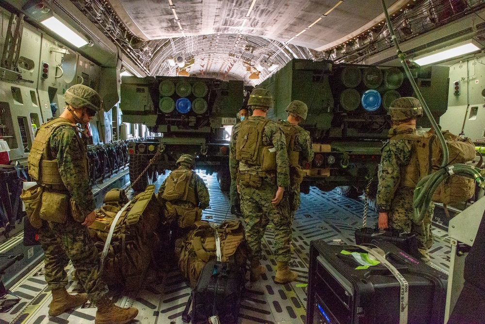 HIMARS unload from a C-17 to conduct HIRAIN during Exercise Loobye