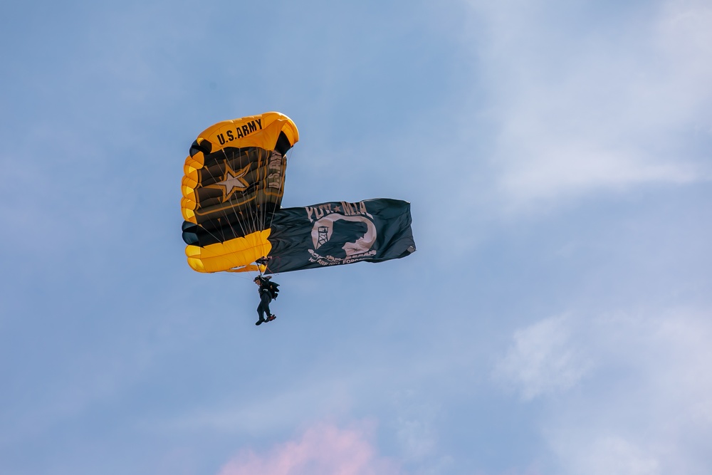 U.S. Army Parachute Team member parachutes with POW/ MIA flag