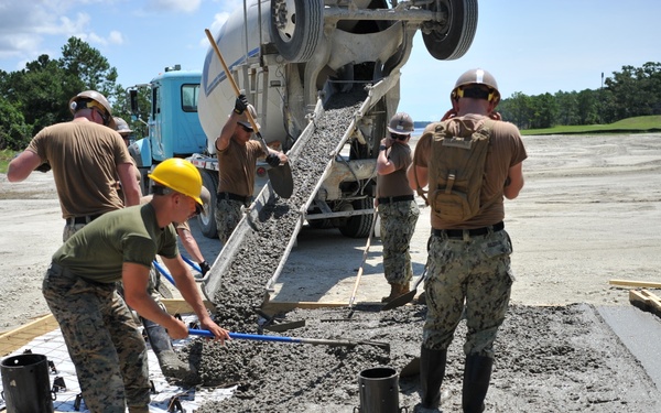 Seabees and Marines place two concrete pads on board Marine Corps Base Camp Lejeune, NC