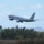 Combat aircraft integrate in Hawaii for exercise Sentry Aloha-21 A U.S. Air Force military tanker aircraft, identifiable as a KC-135 Stratotanker, is captured during takeoff with landing gear still extended. The aircraft bears 'U.S. AIR FORCE' markings on the fuselage and an American flag on the tail fin. The background features a treeline, a distant cityscape, and what appears to be Diamond Head crater in Hawaii, suggesting the location is Joint Base Pearl Harbor-Hickam.