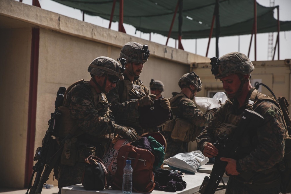 Marines with the 24th Marine Expeditionary Unit (MEU) search luggage during an evacuation at Hamid Karzai International Airport, Kabul, Afghanistan,