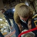 Sailors assigned to the USS America conduct maintenance in the vehicle storage area.