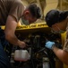 Sailors assigned to the USS America conduct maintenance in the vehicle storage area.
