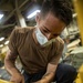Sailors assigned to the USS America conduct maintenance in the vehicle storage area.