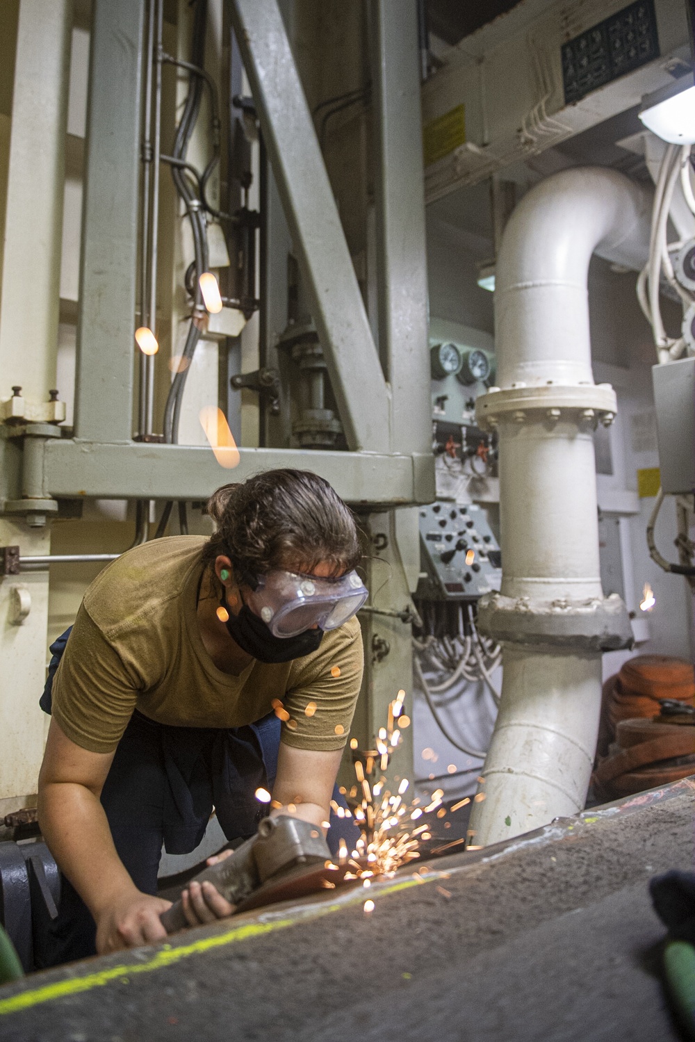 Sailors assigned to the USS America conduct maintenance in the vehicle storage area.