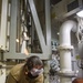 Sailors assigned to the USS America conduct maintenance in the vehicle storage area.