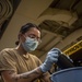Sailors assigned to the USS America conduct maintenance in the vehicle storage area.
