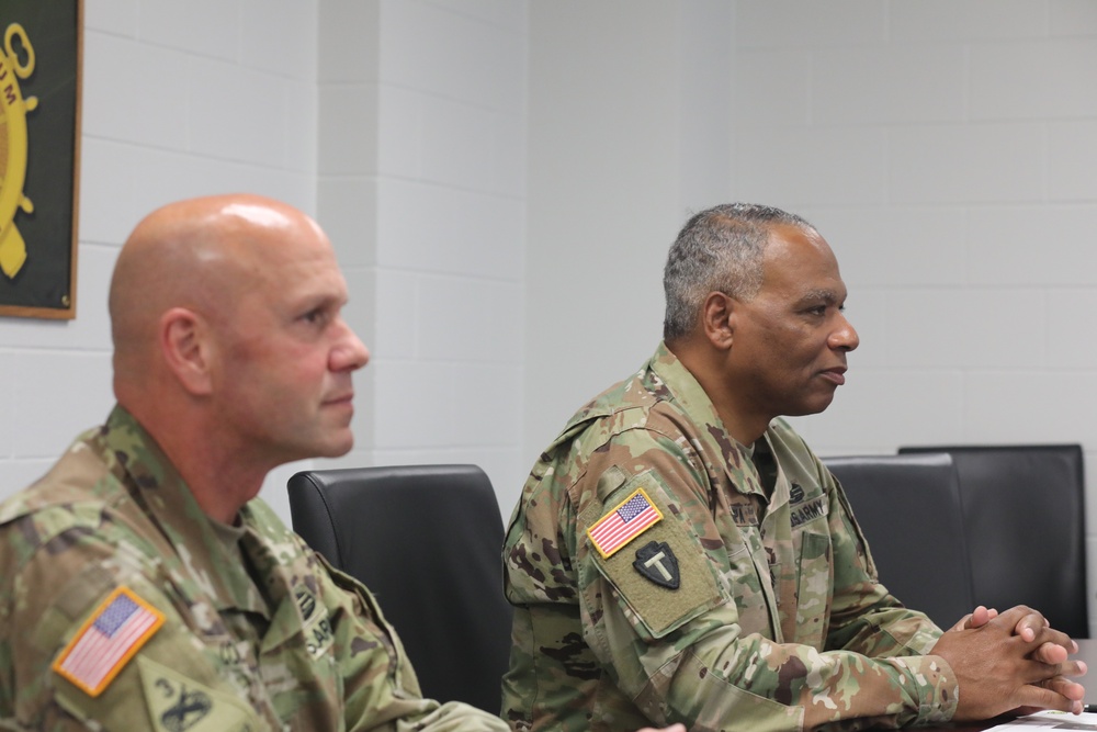 SDNG state command sergeant major Command Sgt. Maj. Patrick Couser sits with National Guard command sergeant major Command Sgt. Maj. John Sampa for a briefing on the Officer Candidate School at Camp Rapid.