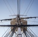 Sailors furl main top sail aboard USS Constitution