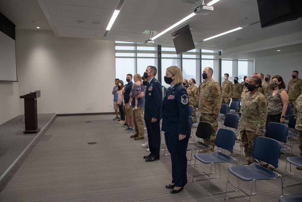 Airmen stand at attention during Master Sgt. Selena Tatum's promotion to Senior Master Sergeant