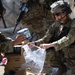 Paratrooper with the 82nd Airborne Division Places Baby Formula into one of the Care Bags