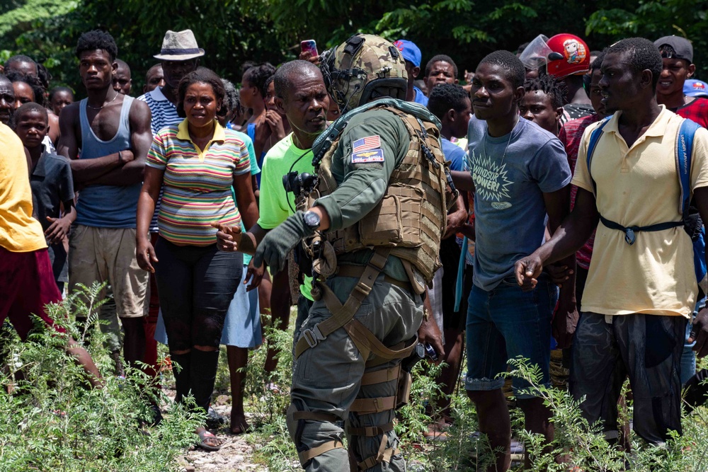 HSC-28 Aircrewman Speaks With Haitians During A Humanitarian Aid Delivery