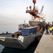 Shipping Containers Of Humanitarian Aid Are Loaded Onto A U.S. Navy LCU