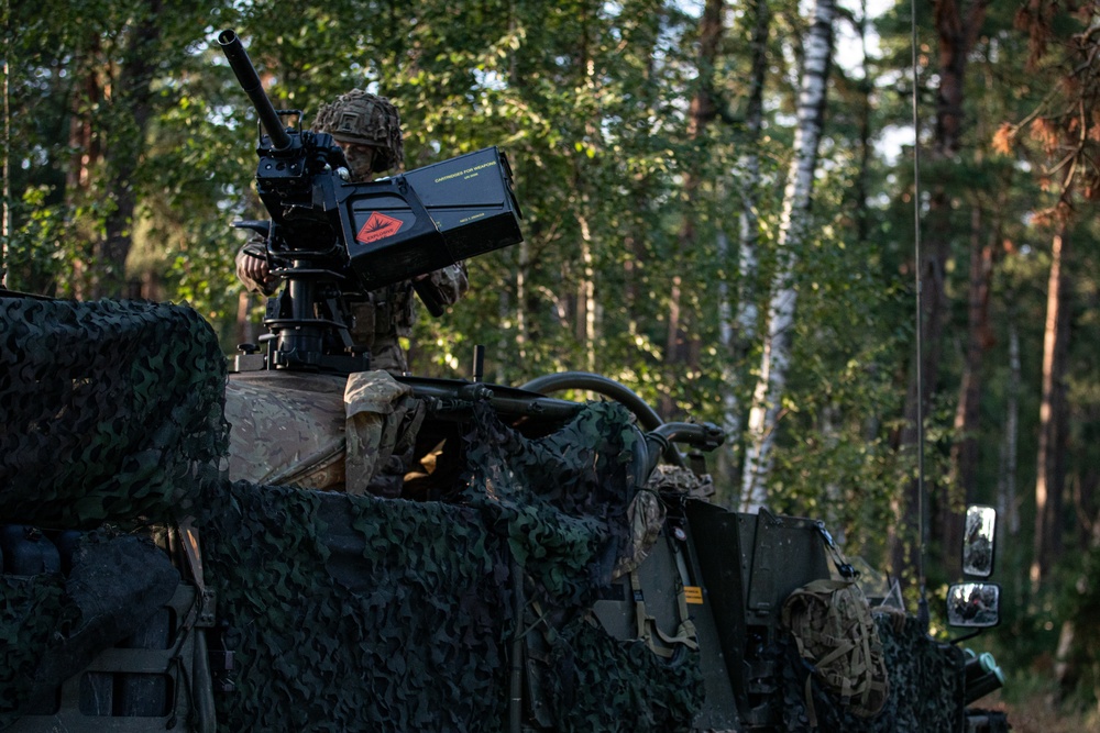 Battle Group Poland's Poacher Troop fires and maneuvers to practice reconnaissance tactics