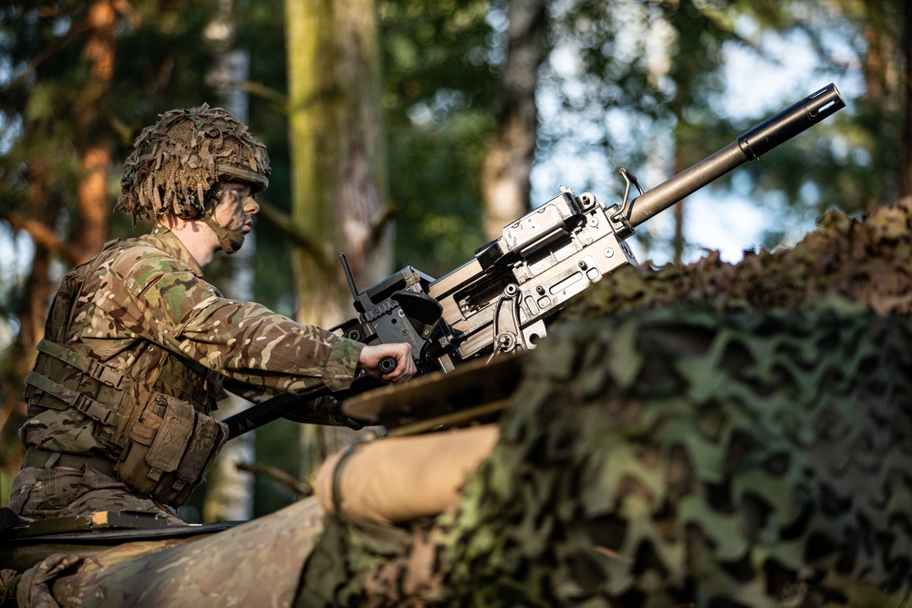 Battle Group Poland's Poacher Troop fires and maneuvers to practice reconnaissance tactics