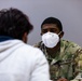 U.S. Army Soldier helps Afghan evacuees begin their In-Processing during Operations Allies Welcome at Fort Pickett, Virginia.