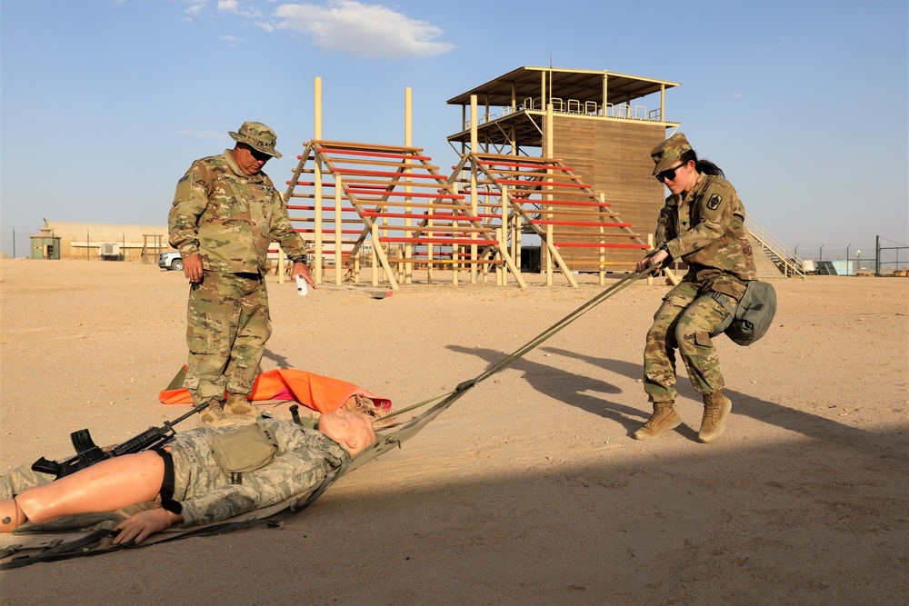 Spc. Grace Tsen completes a medical evacuation test during the Task Force Spartan best warrior competition in Kuwait