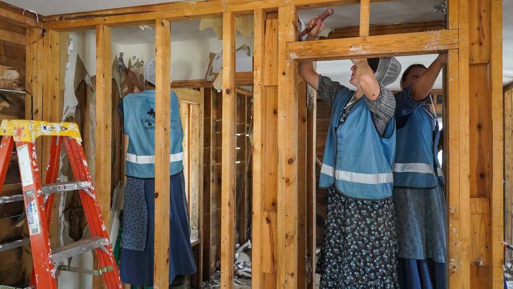 Volunteers Remove Damaged Walls in Flooded Home